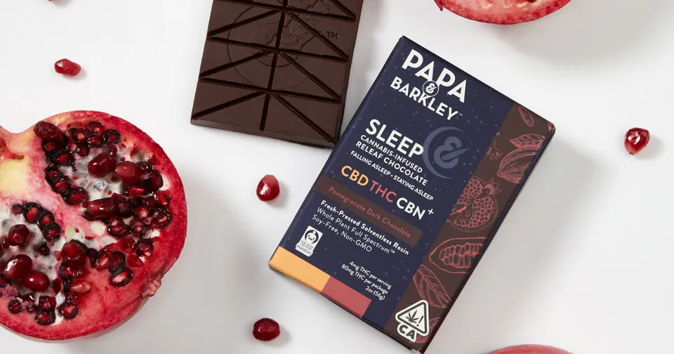 Dark chocolate sleep supplement box with berries and chocolate pieces on a white background
