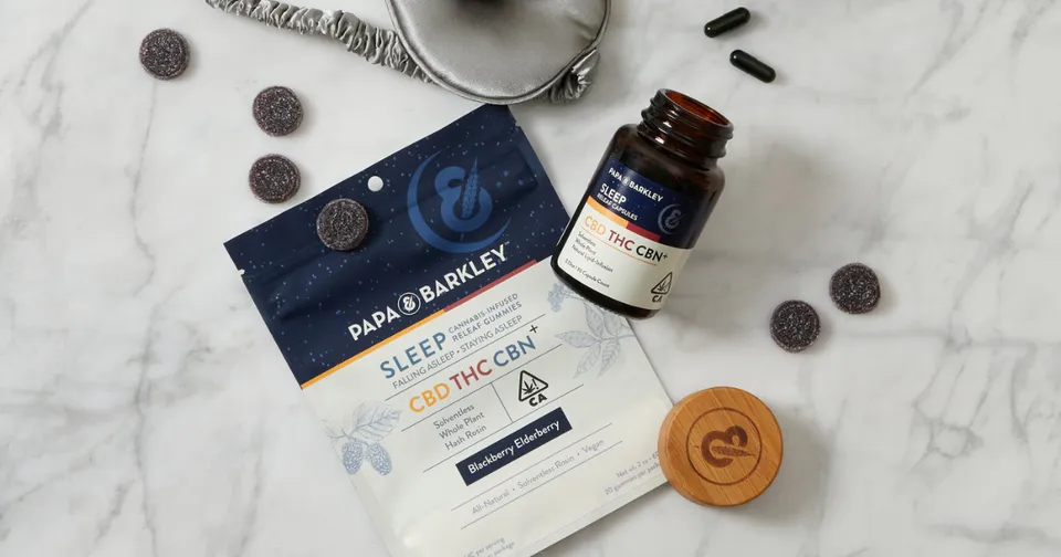 Sleep support supplement bottle and box on a marble surface with earrings and a wooden lid
