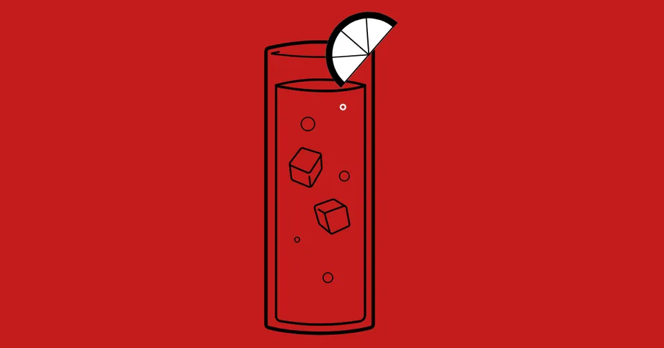 Red cocktail in a tall glass with ice and a lime wedge on a red background