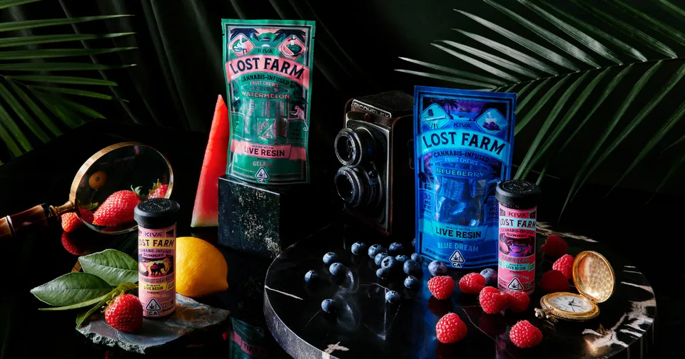 Assorted DistRly cannabis products with colorful packaging, fruit, and a smoking pipe on a dark background