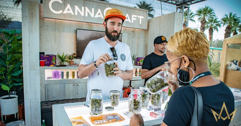 Cannacraft booth with staff serving cannabis products at an outdoor expo